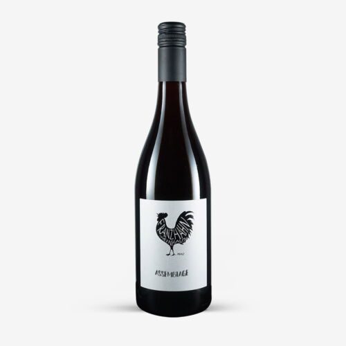 Eine dunkle Glasflasche Assemblage-Wein mit einem schwarzen Schraubverschluss. Auf dem weißen Etikett ist ein schwarzer Hahn über dem Wort "ASSEMBLAGE" abgebildet. Die Flasche ist vor einem schlichten weißen Hintergrund fotografiert.