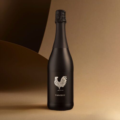 Eine mattschwarze Flasche Schokosecco-Sekt mit einer Hahn-Illustration und "SEKTHAHNCHEN" auf dem Etikett, vor einem Hintergrund mit braunem und beigem Farbverlauf.